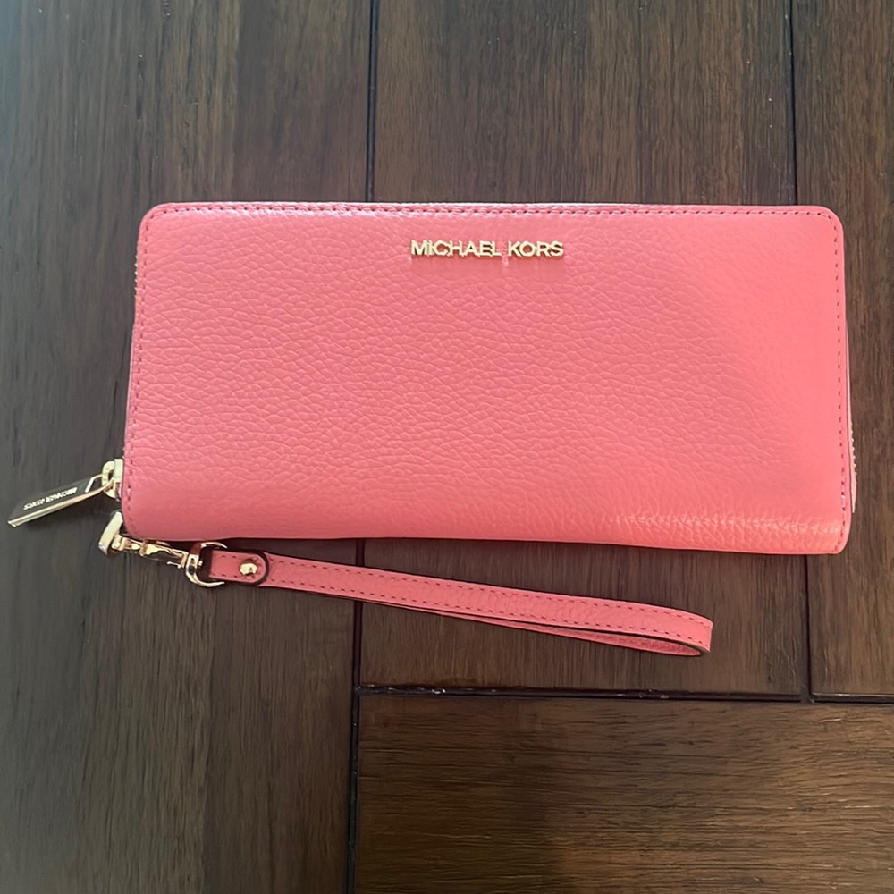 Michael Kors Continental Wristlet. Color is a pinkish-coral.